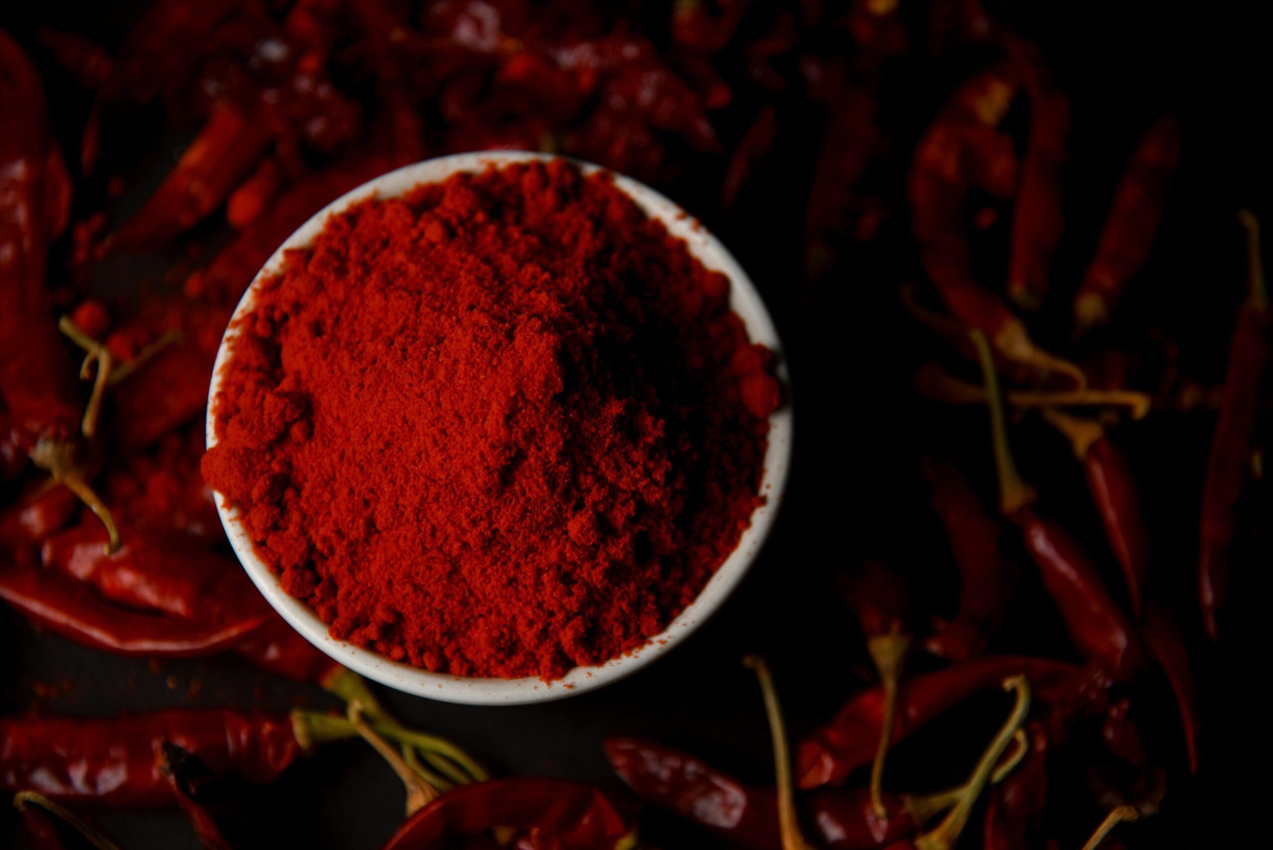 pexels photo 33440710 33440710 Vibrant chili powder in a bowl surrounded by dried red chilies, perfect for spice lovers.
